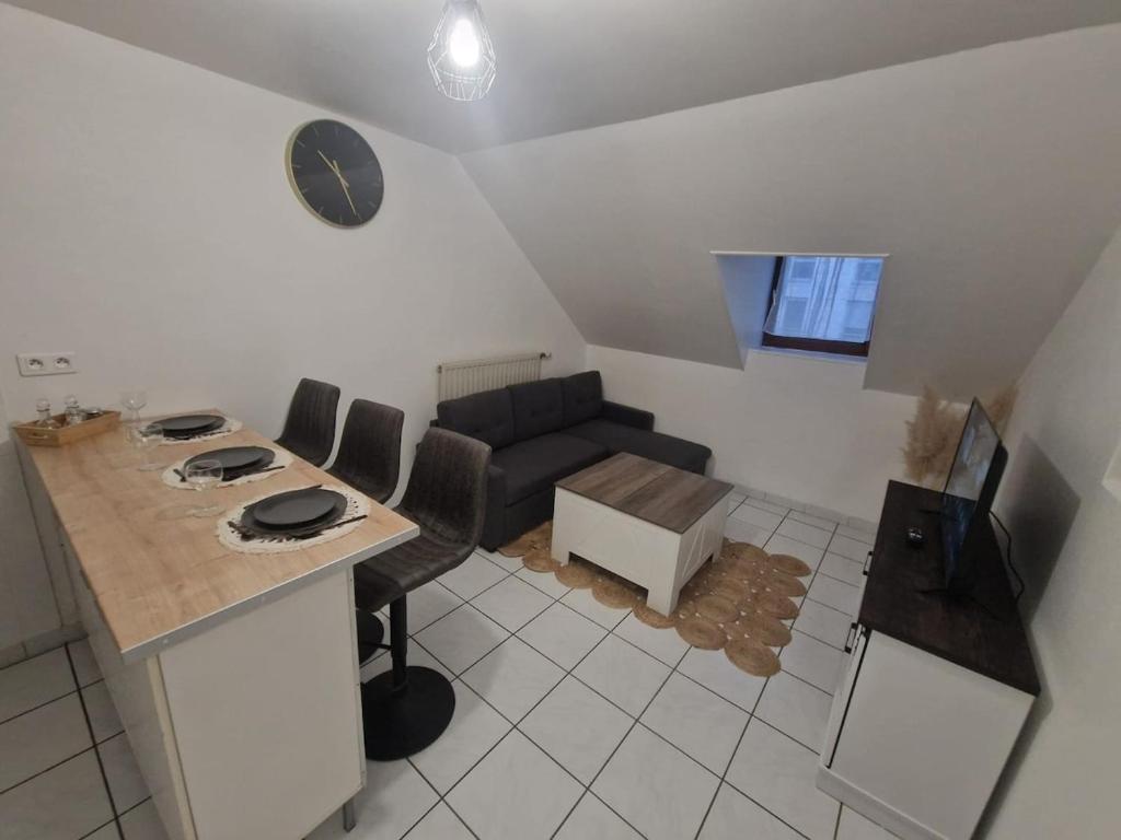 a kitchen and living room with a couch and a table at Le Belfort centre ville in Chalon-sur-Saône