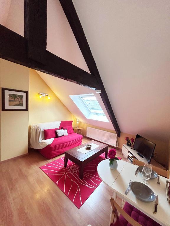 un salon avec un canapé rouge et une table dans l'établissement Au fil du temps, à Morlaix