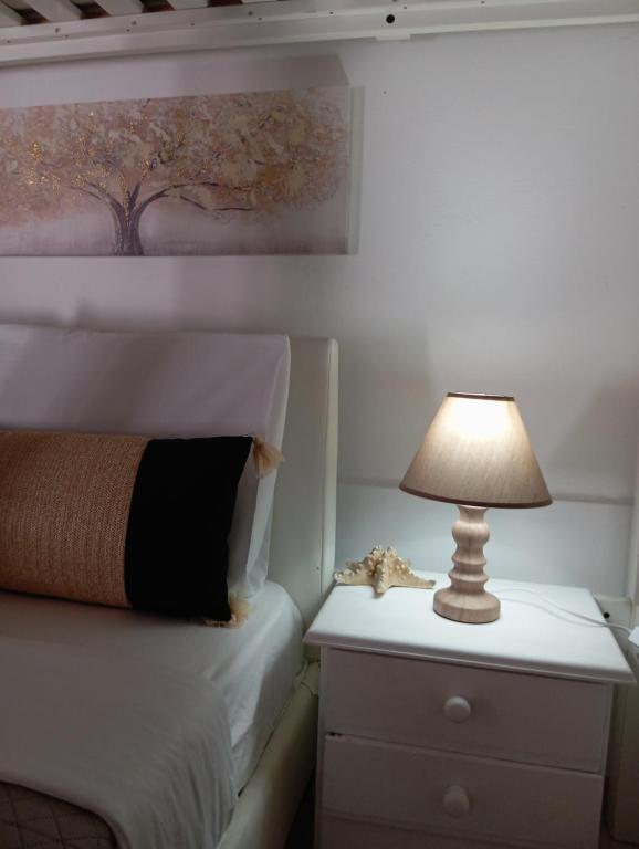 a bedroom with a bed and a lamp on a nightstand at Alice apartment in Mesochórion