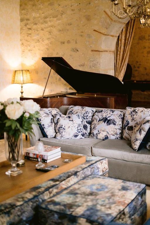 - un salon avec un canapé et un piano dans l'établissement Remarkable renovated castle, à Villeneuve-sur-Lot