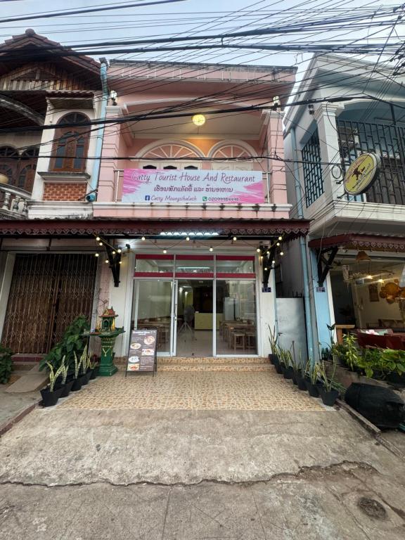 a building with a sign on the front of it at Catty tourist house in Thakhek
