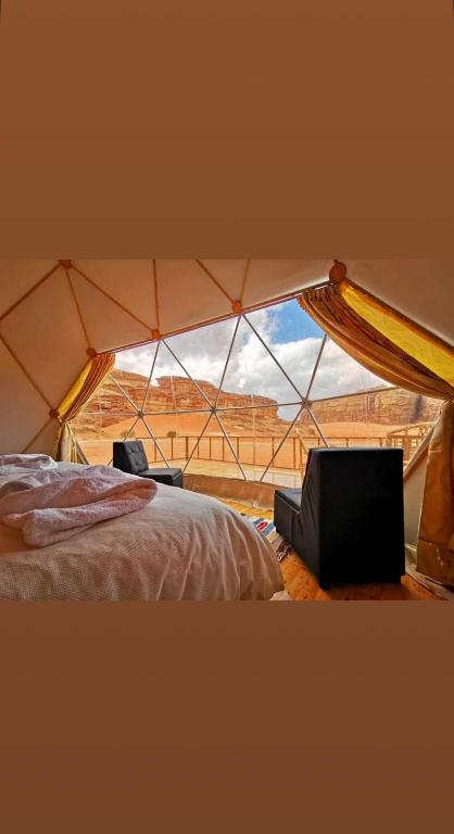 a room with a bed and a window in a tent at Madar Camp, Wadi Rum in Wadi Rum