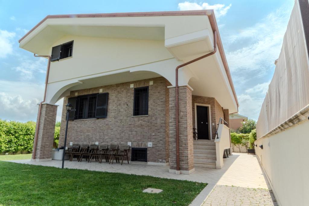 a building with a patio with tables and chairs at Casa Gaia - Villetta a pochi passi da Roma in Ciampino