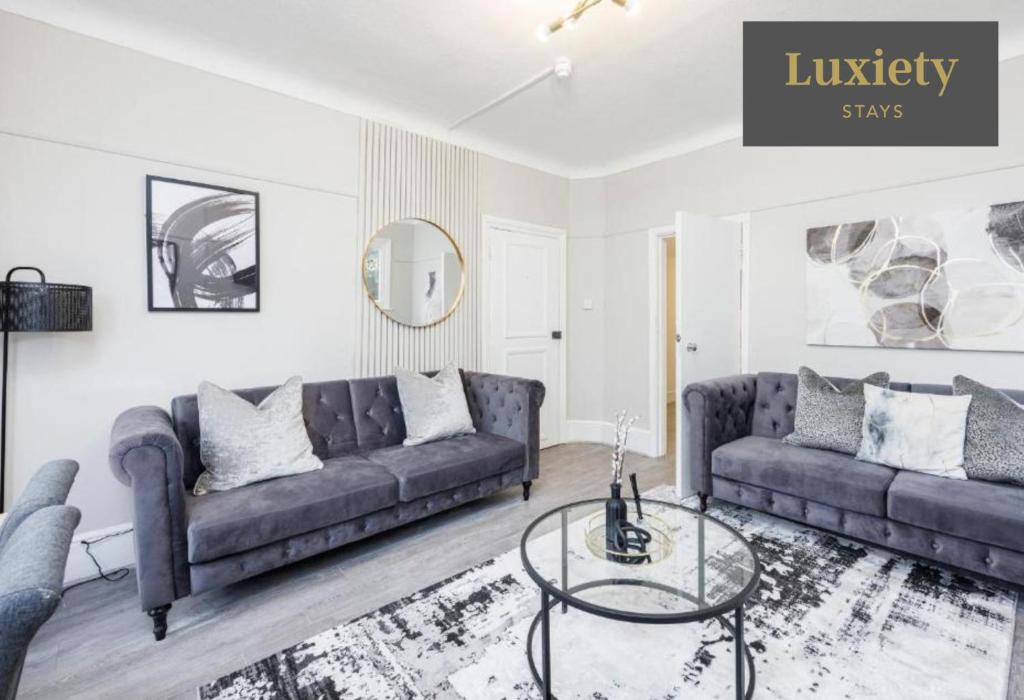 サウスエンド・オン・シーにあるModern & Stylish 2BR - CITY CENTRE Nr High Street & C2C by Luxiety Staysのソファ2つとガラスのテーブルがあるリビングルーム