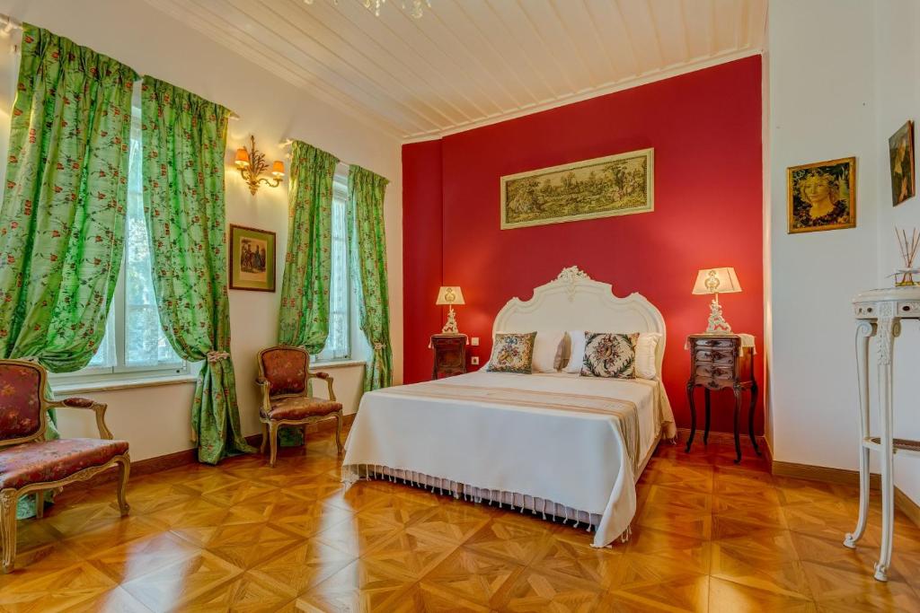 a bedroom with a white bed and red walls at IPEKYOL Guesthouse in Çeşme
