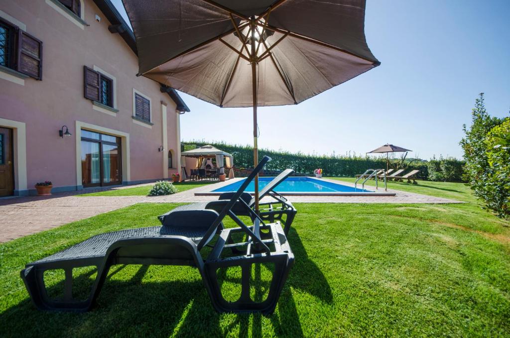 two chairs and an umbrella next to a pool at Villa Gilda in Bracciano
