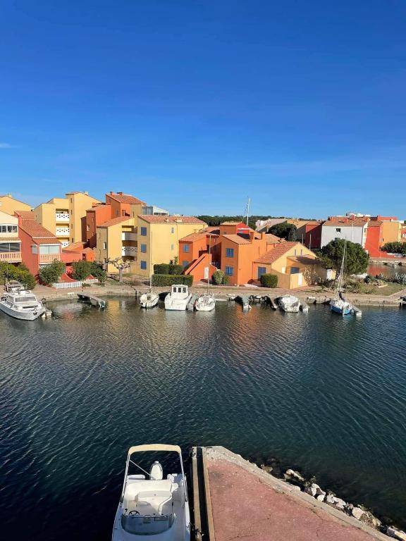 un bateau est amarré dans un port avec des bâtiments dans l'établissement Studio cabine à barcares, au Barcarès