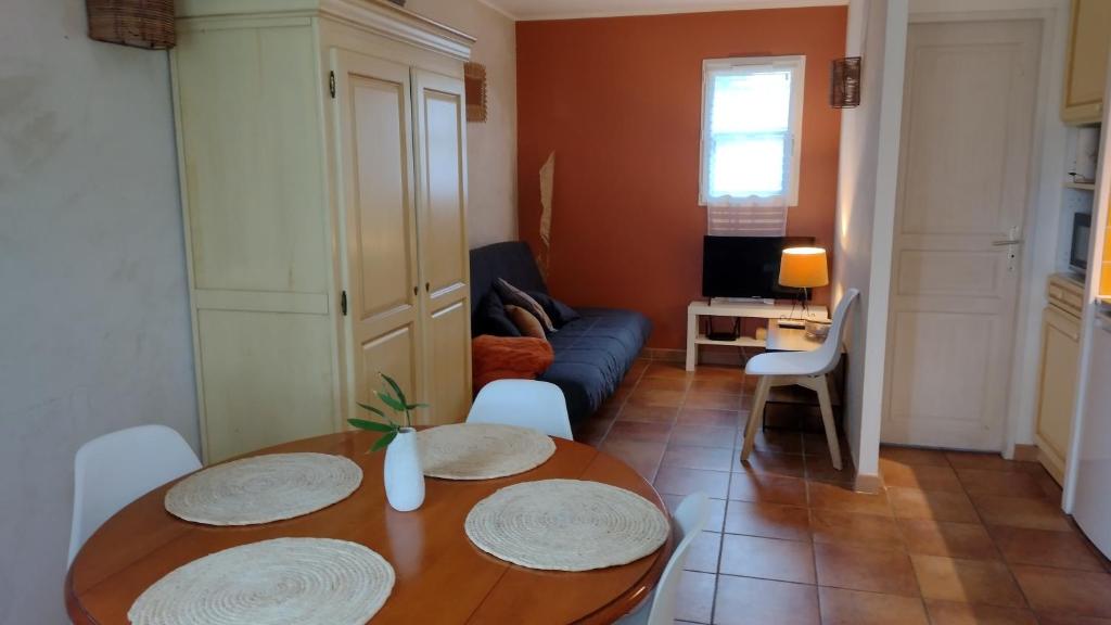 een woonkamer met een tafel en een bank bij Vacances en Camargue proche de la mer climatisé in Aigues-Mortes
