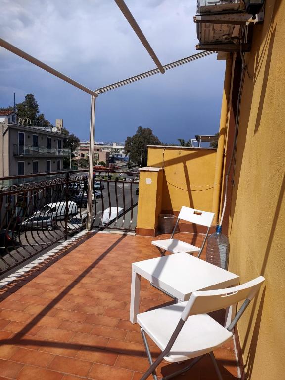 two white chairs on a balcony with a view at Bed and fly Aeroporto Catania in Catania