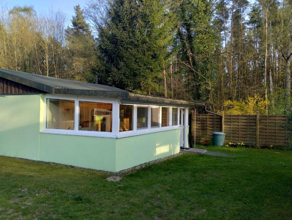 ein grünes und weißes Haus in einem Hof in der Unterkunft Ferienhaus am Müritz Nationalpark in Waren (Müritz)