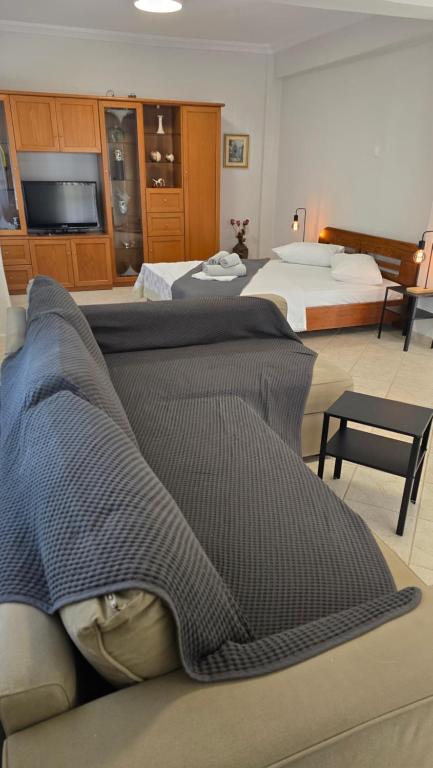 a hotel room with two beds and a television at Lucky Apartment in Nea Kalikratia