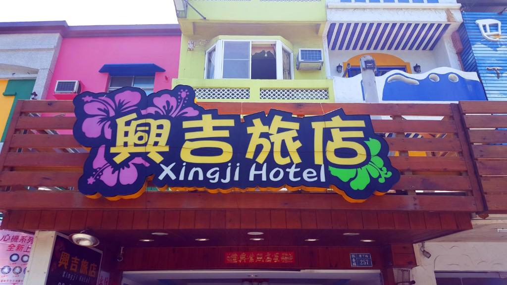 a sign for a kiwi hotel on a building at Xing Ji Hotel in Kenting