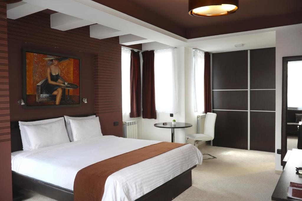 a bedroom with a bed and a table in a room at Sienna Apartments in Skopje