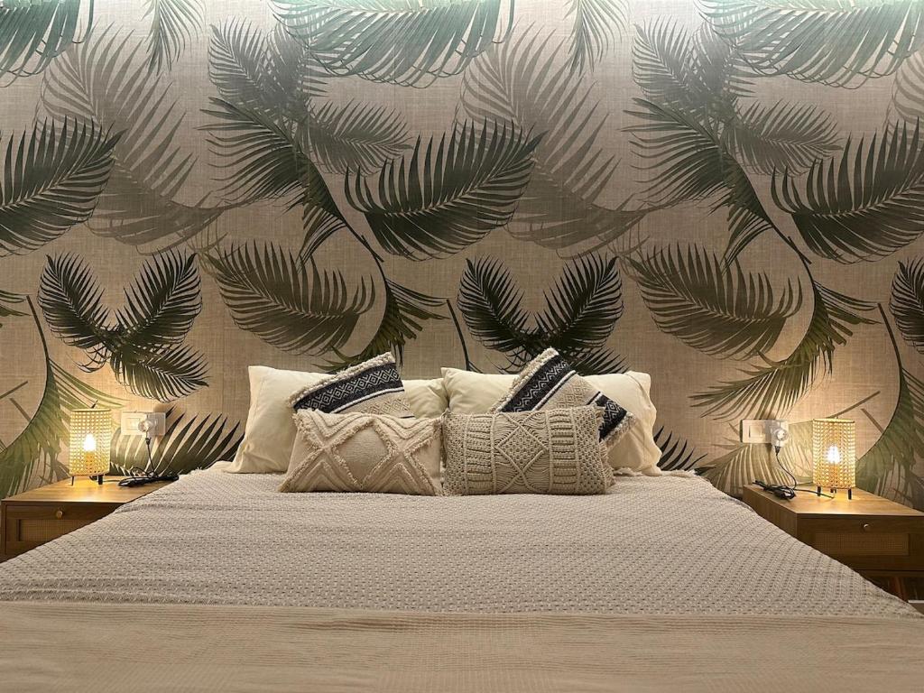 a bedroom with a bed with a mural of leaves at Paraíso en Fuerteventura in Costa Calma