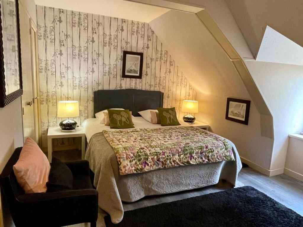 une chambre avec un lit et une chaise dans l'établissement Appart'hotel Maison Saint Michel, à Paimpol