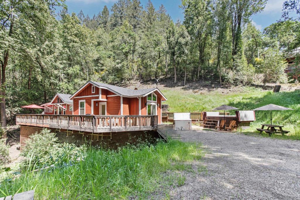 a log cabin with a deck and a picnic table at Modern Cabin Retreat with Swim Spa Hot Tub and Air Conditioning in Forestville