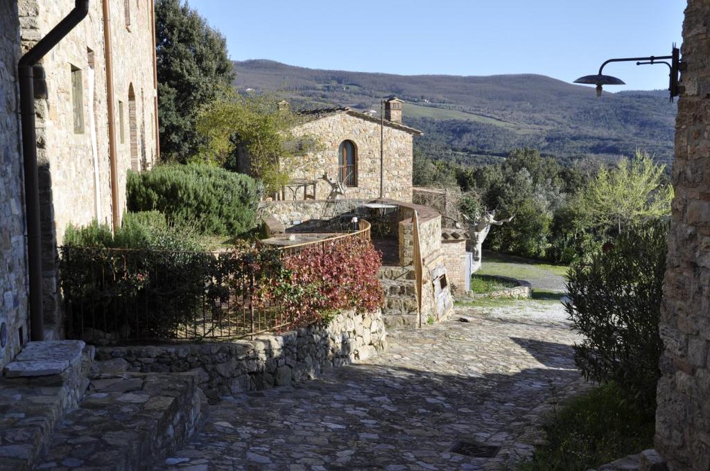 an alley in an old stone building with a fence at Borgo Mommialla Boscaiola in Bagni di Mommialla