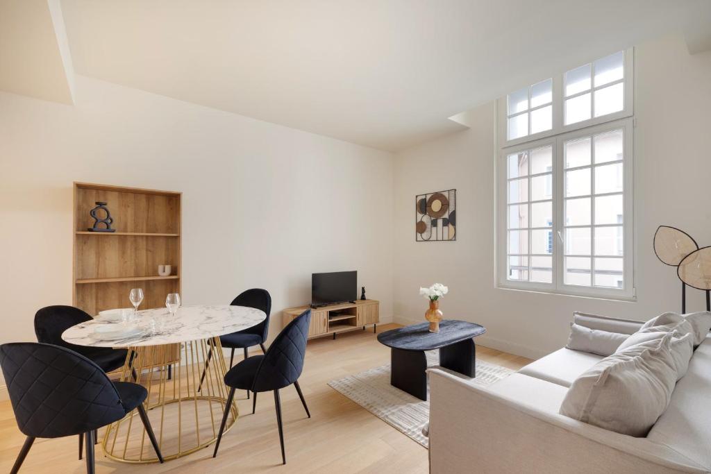 un salon avec une table, des chaises et un canapé dans l'établissement Appartement Place de Gaulle - Welkeys, à Antibes