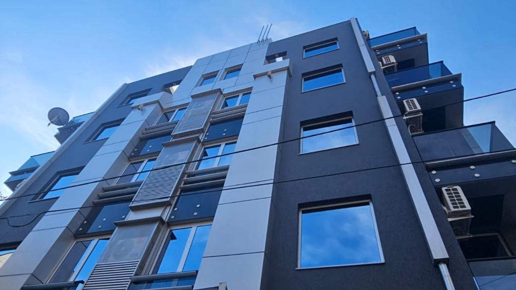 a building with blue windows on the side of it at Sienna Apartments in Skopje