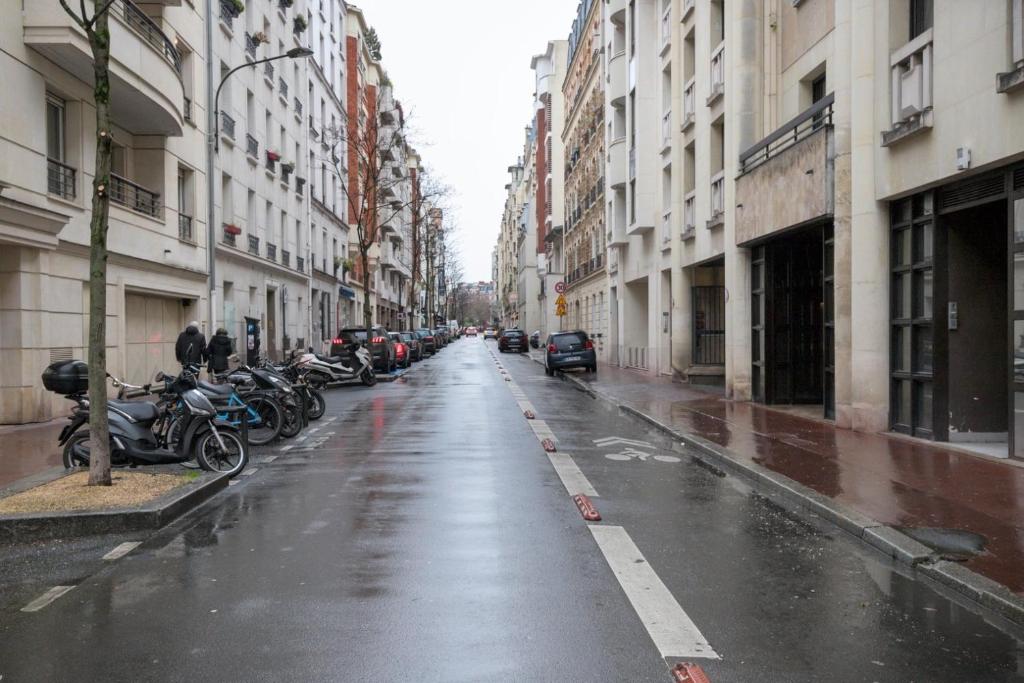 une rue humide avec des motos garées sur le côté dans l'établissement One bedroom apartment with its modern decor - CheckProfile, à Levallois-Perret