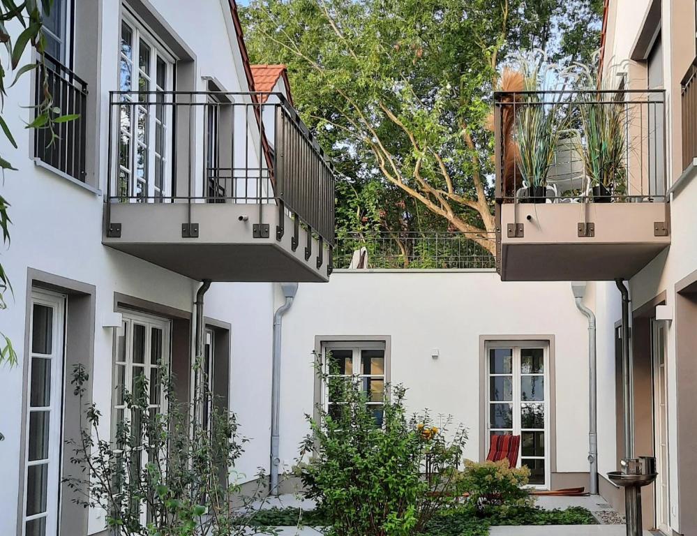 Dos balcones en un edificio blanco con plantas. en Seeapartment Wustrau, en Wustrau