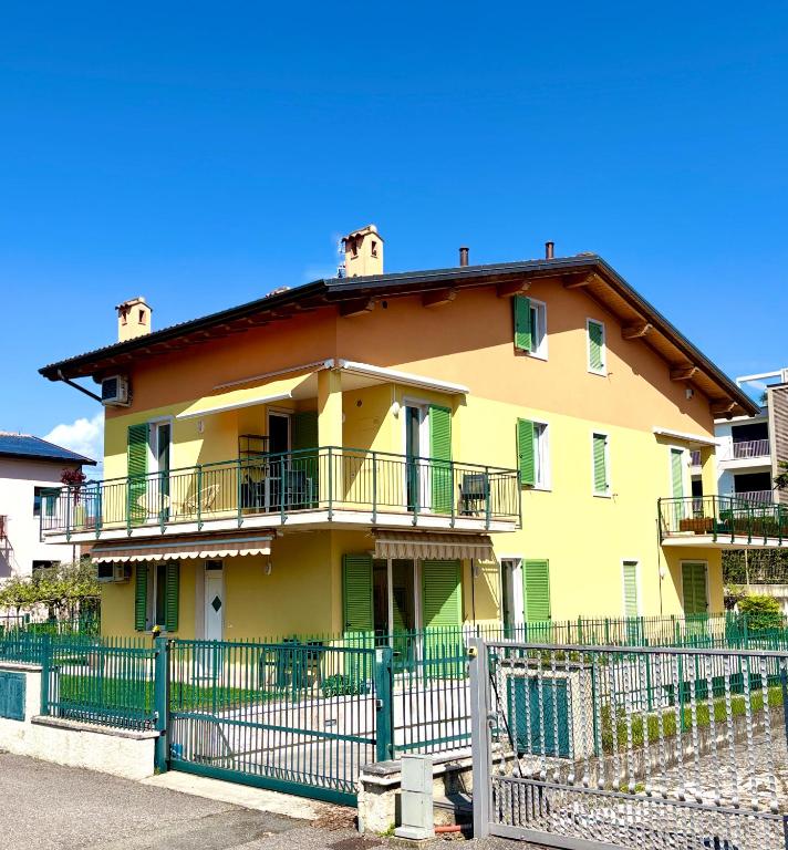 a yellow house with a fence in front of it at La Casetta Lazise in Lazise