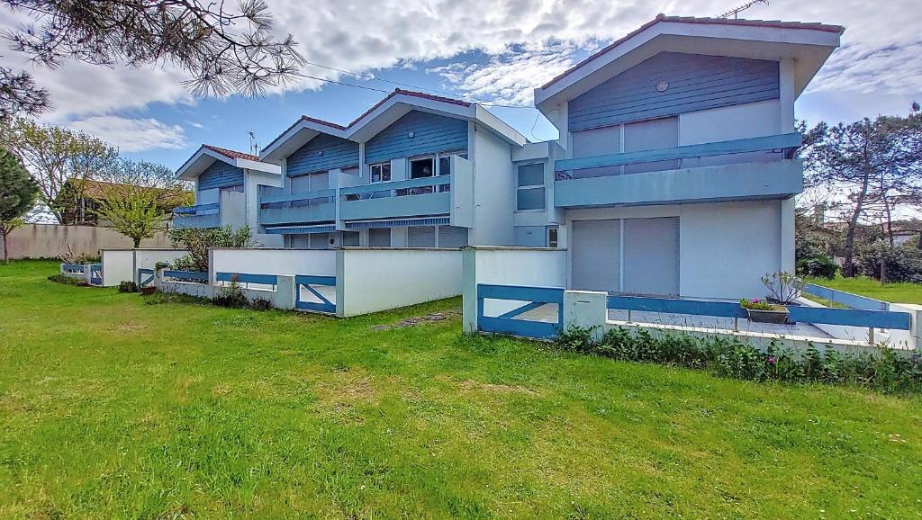 une grande maison bleue avec une cour verdoyante dans l'établissement V-Sable d'or 01-Vieux Boucau Appartement 3 pièces proche de l'océan, à Vieux-Boucau-les-Bains