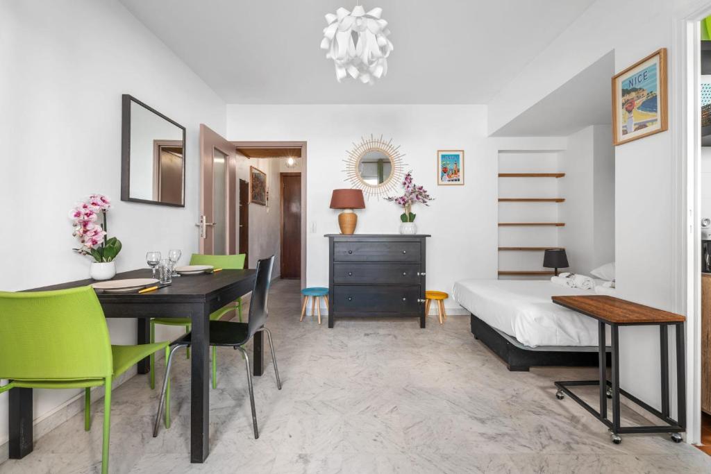 une chambre avec un lit, une table et des chaises dans l'établissement Studio Malaussena - Welkeys, à Nice