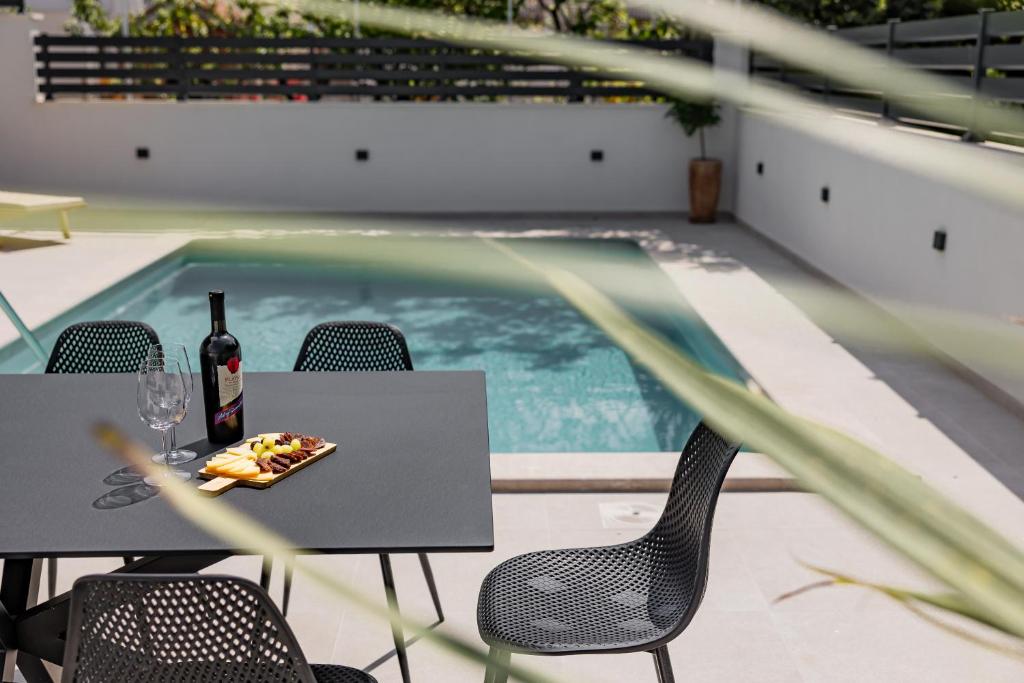 einen Tisch mit einer Flasche Wein und einem Teller Essen in der Unterkunft Villa Luce in Podstrana