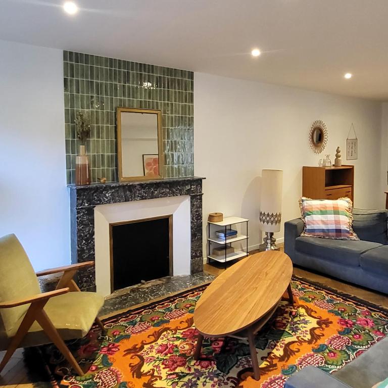 un salon avec un canapé et une cheminée dans l'établissement Maison Marcel, à Écueil