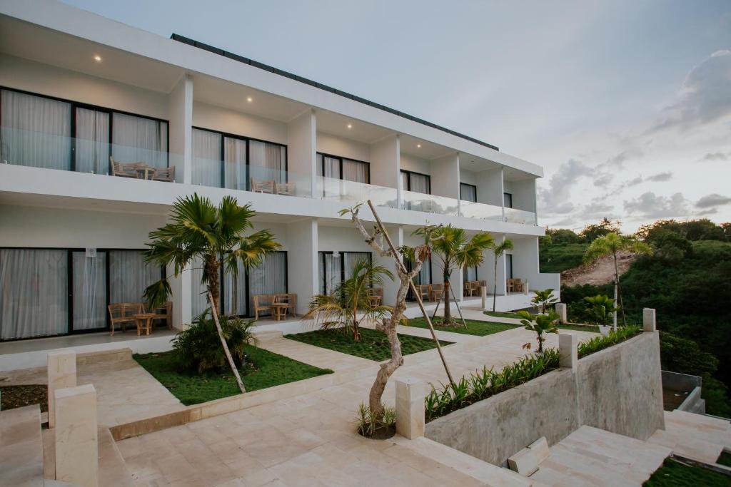 an exterior view of a building with palm trees at De Vindra Resort in Nusa Penida
