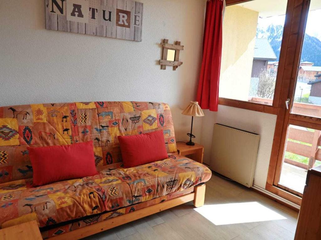 - un canapé avec deux oreillers rouges dans le salon dans l'établissement Studio pour 4 à Vallandry, proche des pistes avec TV et balcon - FR-1-411-277, à Landry