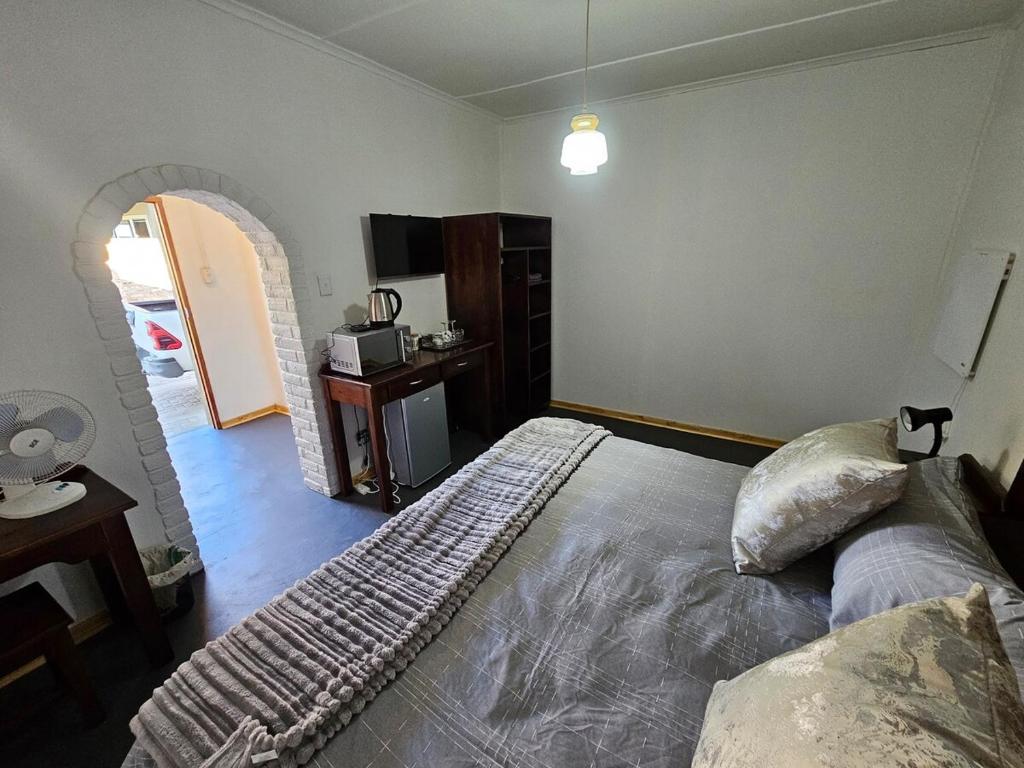 a bedroom with a bed with a keyboard on it at Longe De Casa in Colesberg
