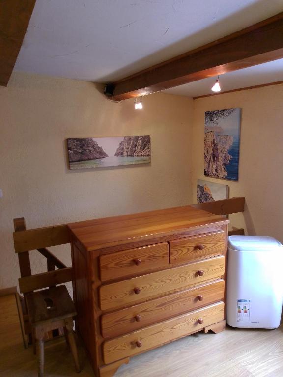 a bedroom with a wooden dresser and a refrigerator at Cabanon du Pêcheur, Parc National des Calanques in Marseille