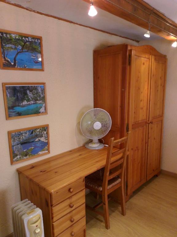 a desk with a fan and a chair in a room at Cabanon du Pêcheur, Parc National des Calanques in Marseille