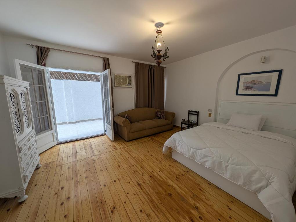a bedroom with a bed and a couch and a window at Villa Maadi 35 -R 102- Terrace View Room 2 in Cairo