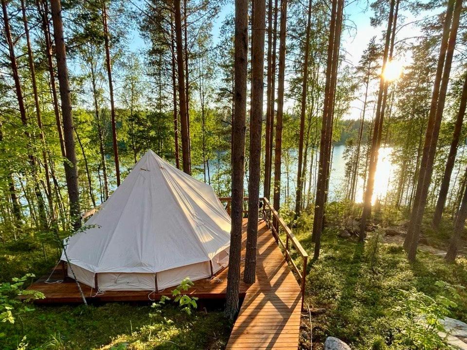 a tent in the middle of a forest at Alaska Glamping Linnansaari in Savonlinna