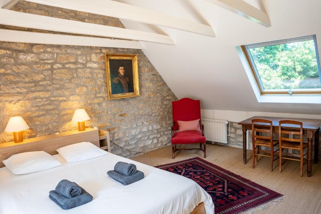 a bedroom with two beds and a stone wall at Ker Forn By Nid 'Ouest in Plobannalec-Lesconil