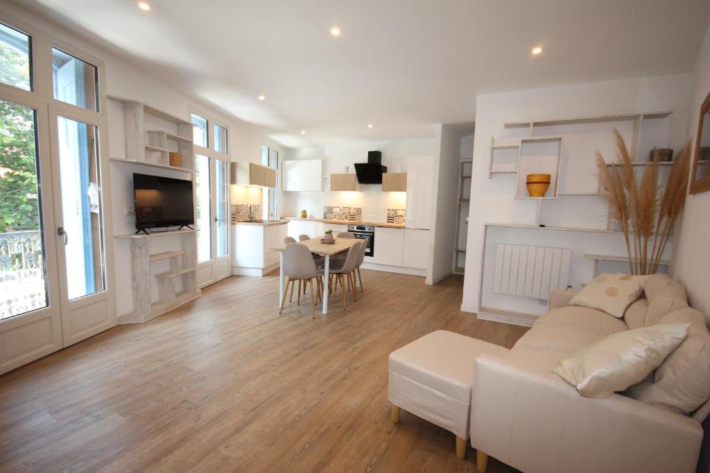 un salon avec un canapé blanc et une table dans l'établissement Le Boutigué, à Collioure