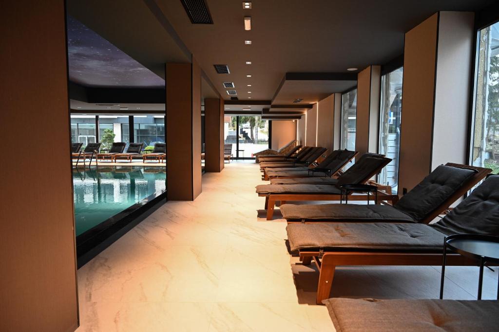 a row of chaise lounge chairs in a room with a pool at Modena Resort Spa & Wellness Zlatibor in Zlatibor