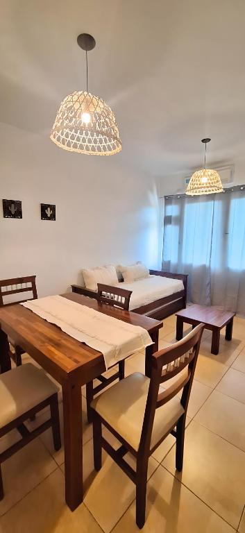 a dining room with tables and chairs and a couch at Las Tulmas Apartamentos Salta in Salta