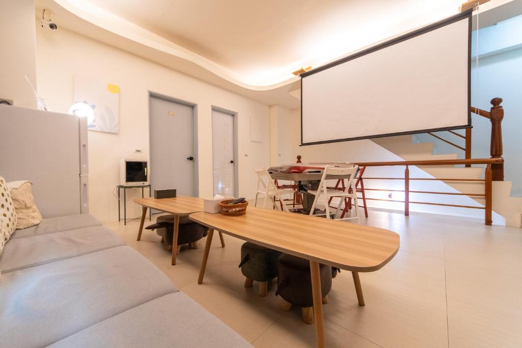 un salon avec une table et un grand écran dans l'établissement 旅人之宿Traveler Inn依預定人數開放房間數, à Hualien