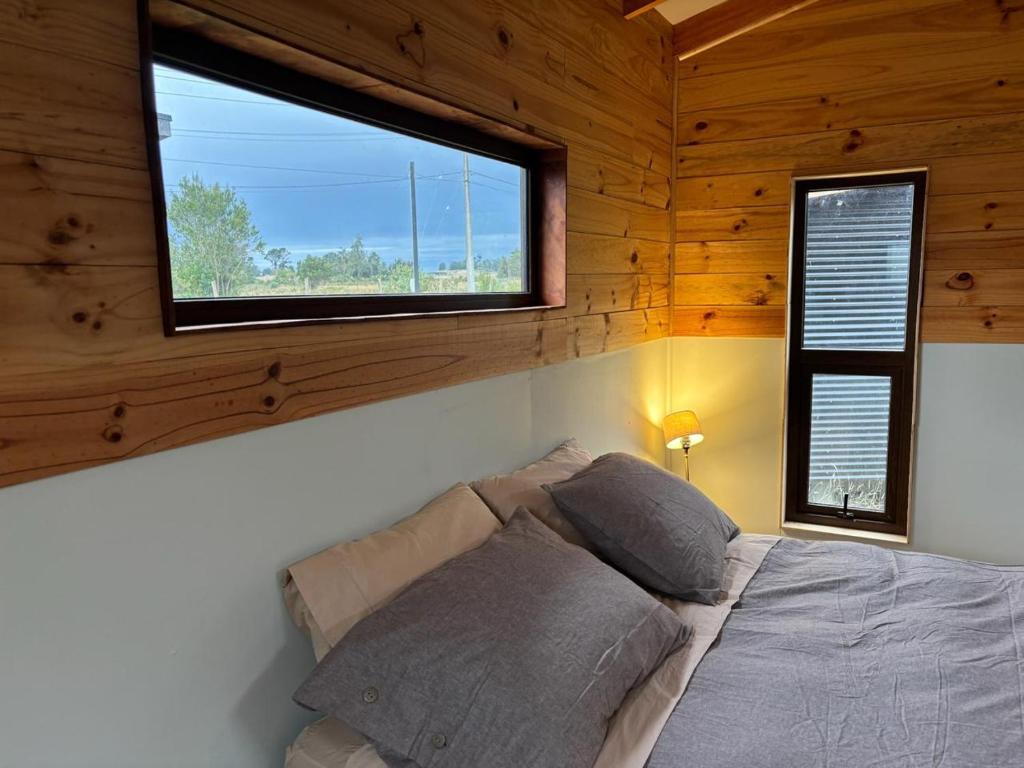 um quarto com uma cama e uma janela num camarote em Cabañas Rewe del Maulllin em Puerto Varas