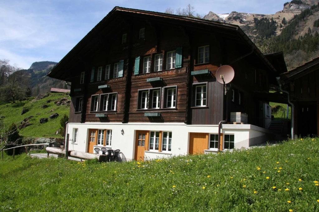a large wooden house on top of a hill at Beim See in Grindelwald
