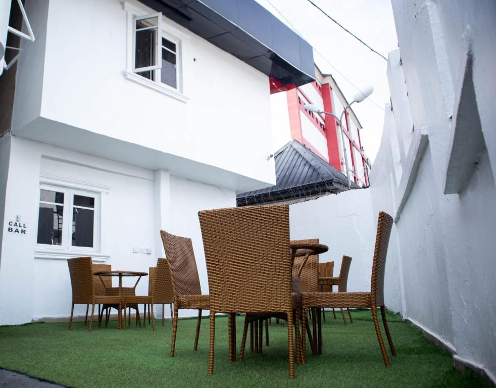 eine Gruppe von Stühlen und Tischen außerhalb eines Gebäudes in der Unterkunft Option one hotel and suite in Benin-Stadt