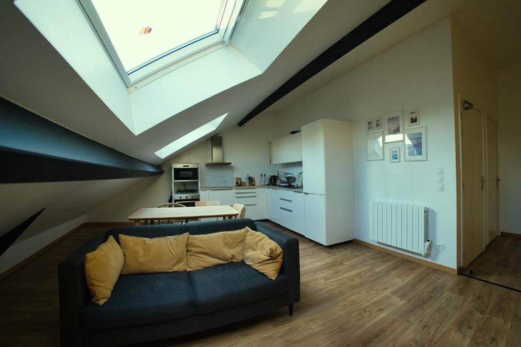 - un salon avec un canapé et une lucarne dans l'établissement Chambres 18m2, SDB PV, Centre, WIFI, Appart 100m2, à Tourcoing