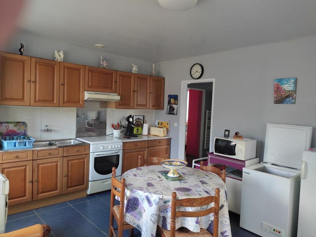 a kitchen with a table and a white refrigerator at Mimi in Quend