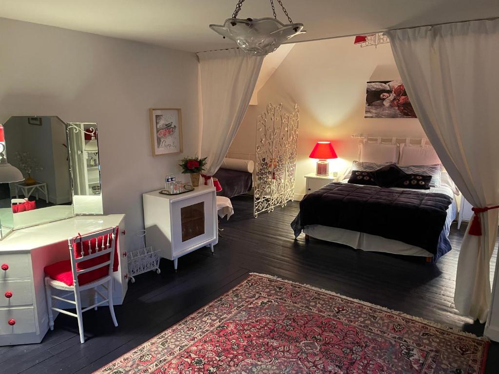 a bedroom with a bed and a desk and a bed sidx sidx sidx at L'Auberge du Château in Tilloloy