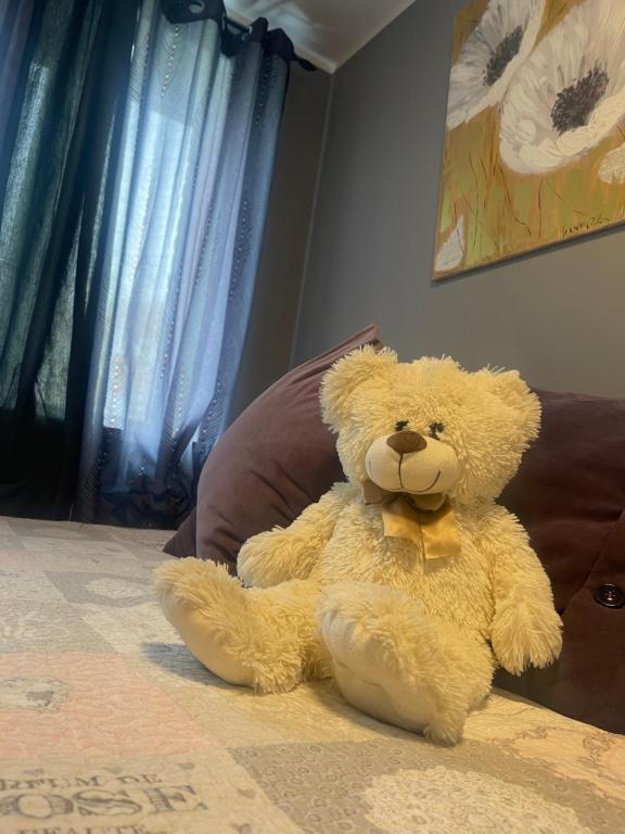 a stuffed teddy bear sitting on a bed at VPhouseVP in Sillamäe