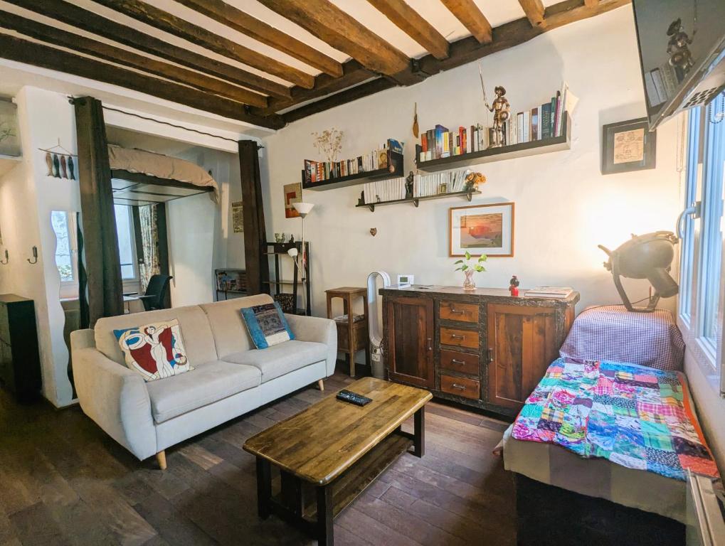 un salon avec un canapé et une table dans l'établissement Charming pied-à-terre - Marais, à Paris